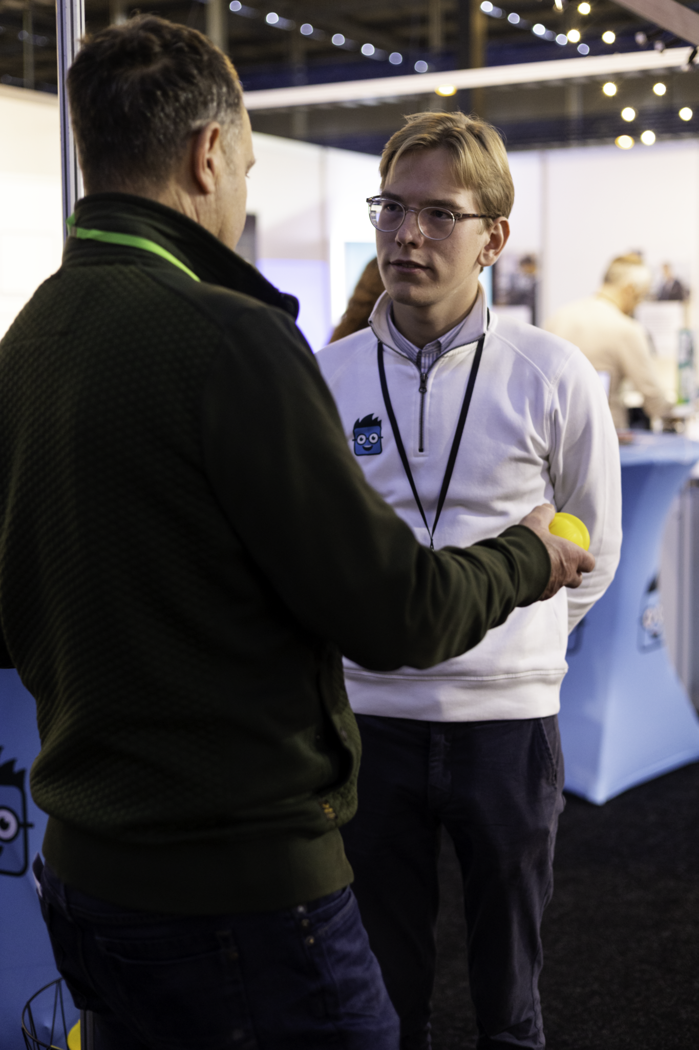 Bezoeker spreekt met een Simple-Simon medewerker op een vakbeurs over digitale werkbonnen en buitendienstsoftware.