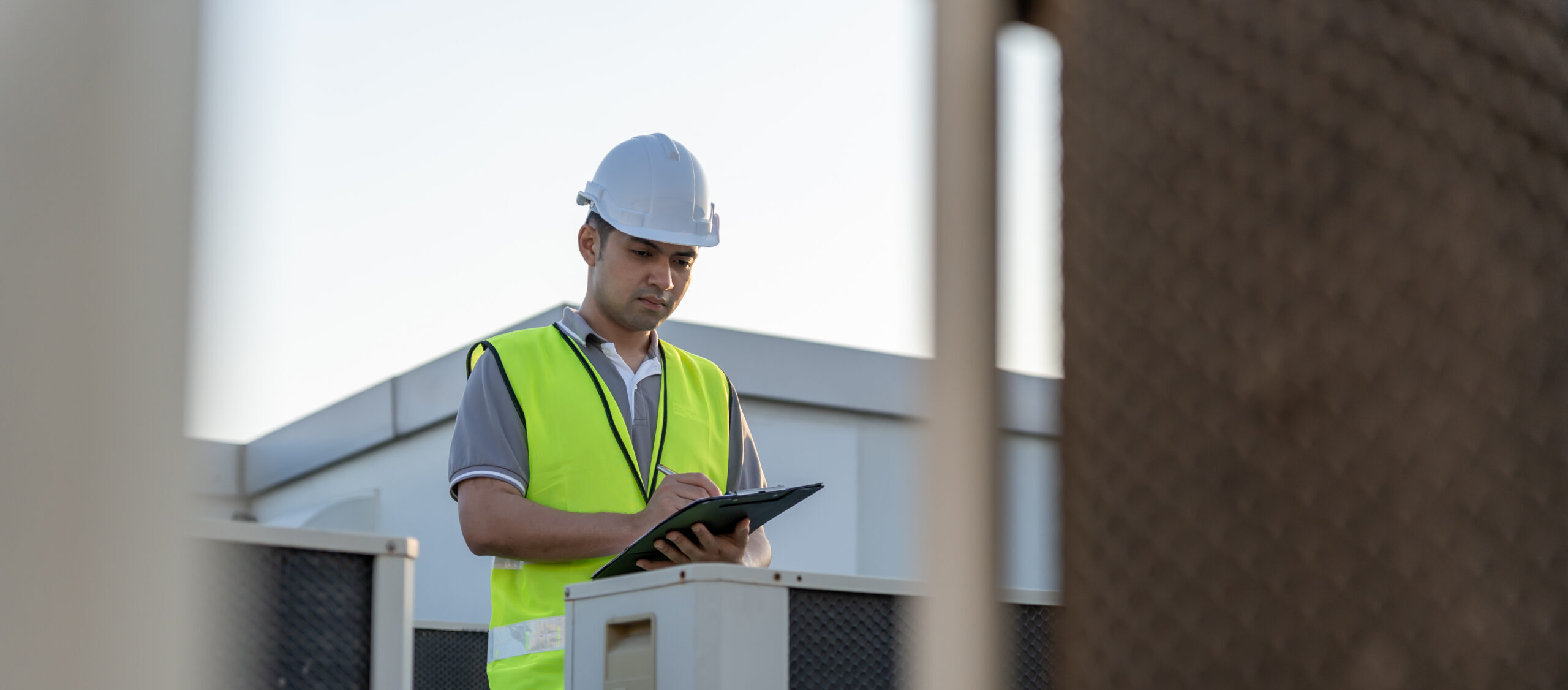 maintenance engineer works on the roof of factory. contractor inspect compressor system and plans installation of air condition systems in construction. Checklist, inspector, control