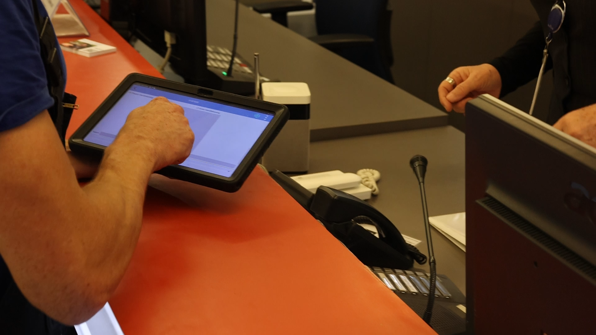 Monteur gebruikt een tablet om een digitale werkbon af te ronden bij de klant.