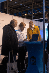 Simple-Simon medewerker geeft een live demo van de werkbon app aan bezoekers op een vakbeurs.