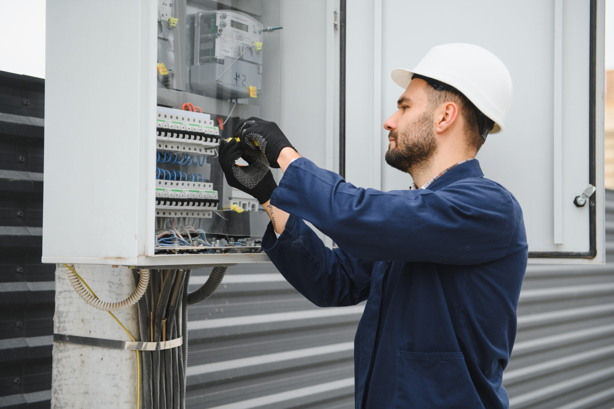 Elektricien inspecteert een groepenkast om overbelasting en brand in de meterkast te voorkomen.