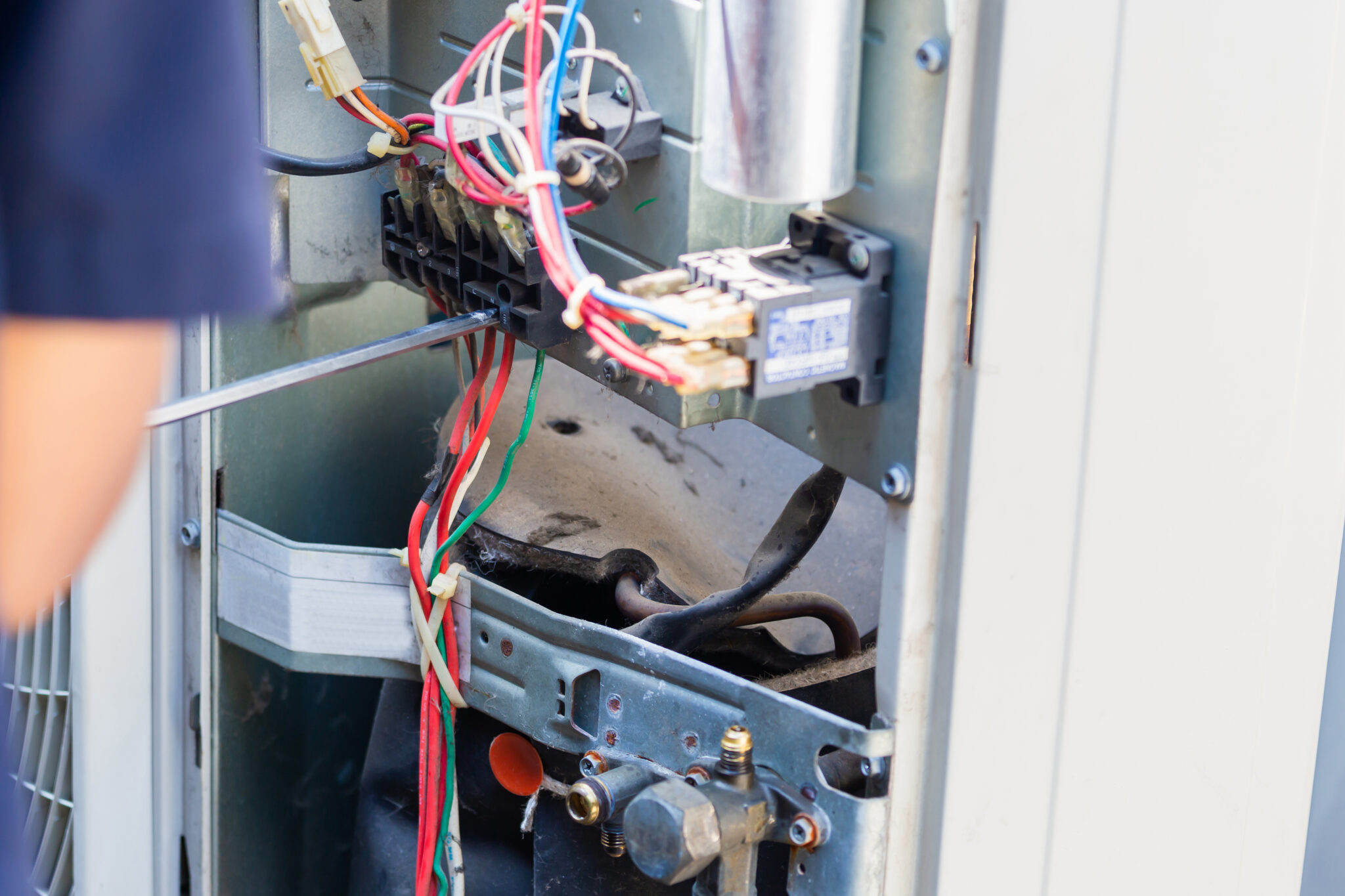 Monteur controleert de elektrische bedrading van een technische installatie om oververhitting en brandrisico te voorkomen.