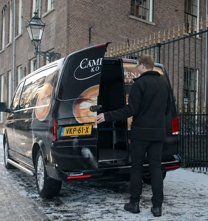 Servicemonteur bij bedrijfswagen op weg naar een klant.