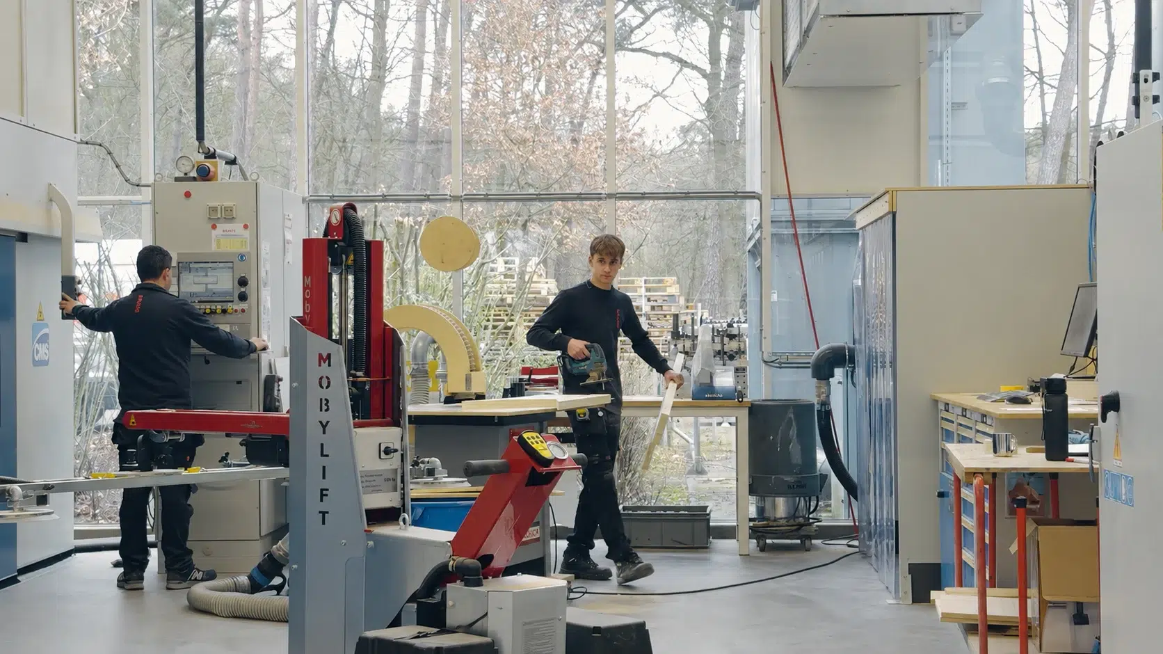 Monteurs aan het werk met machines in een technische werkplaats.