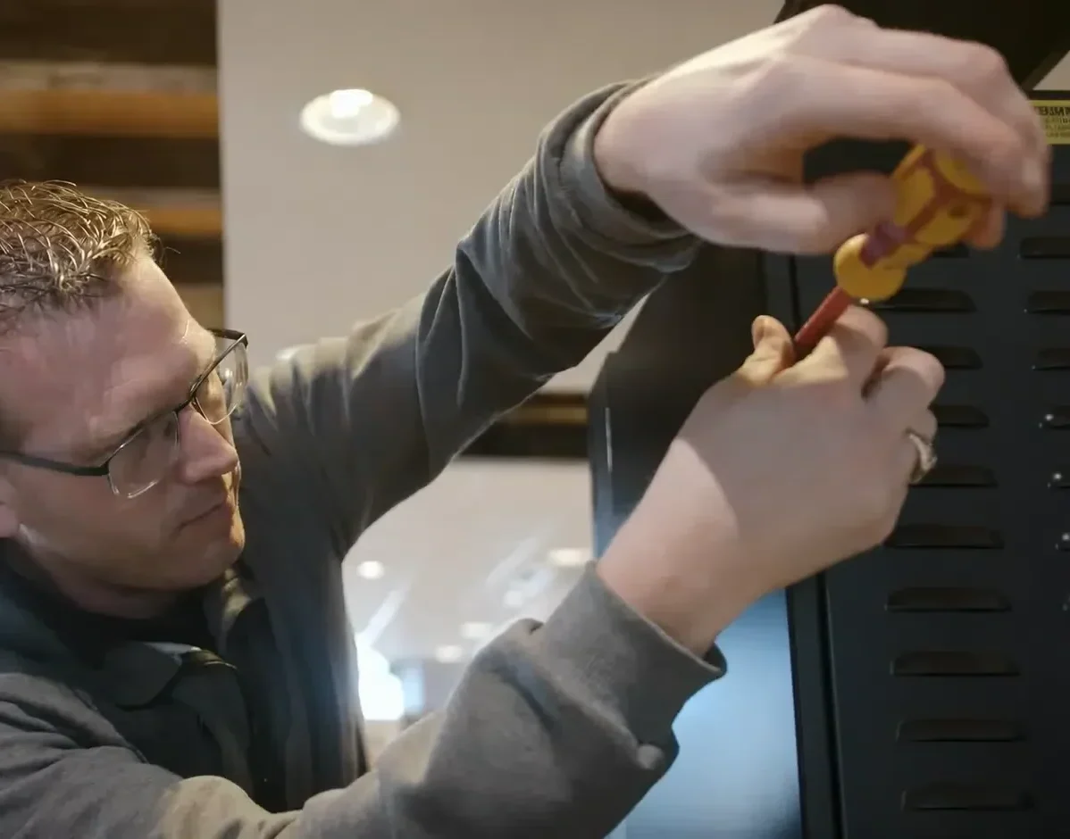 Servicemonteur voert reparatie en onderhoud uit aan technische apparatuur.
