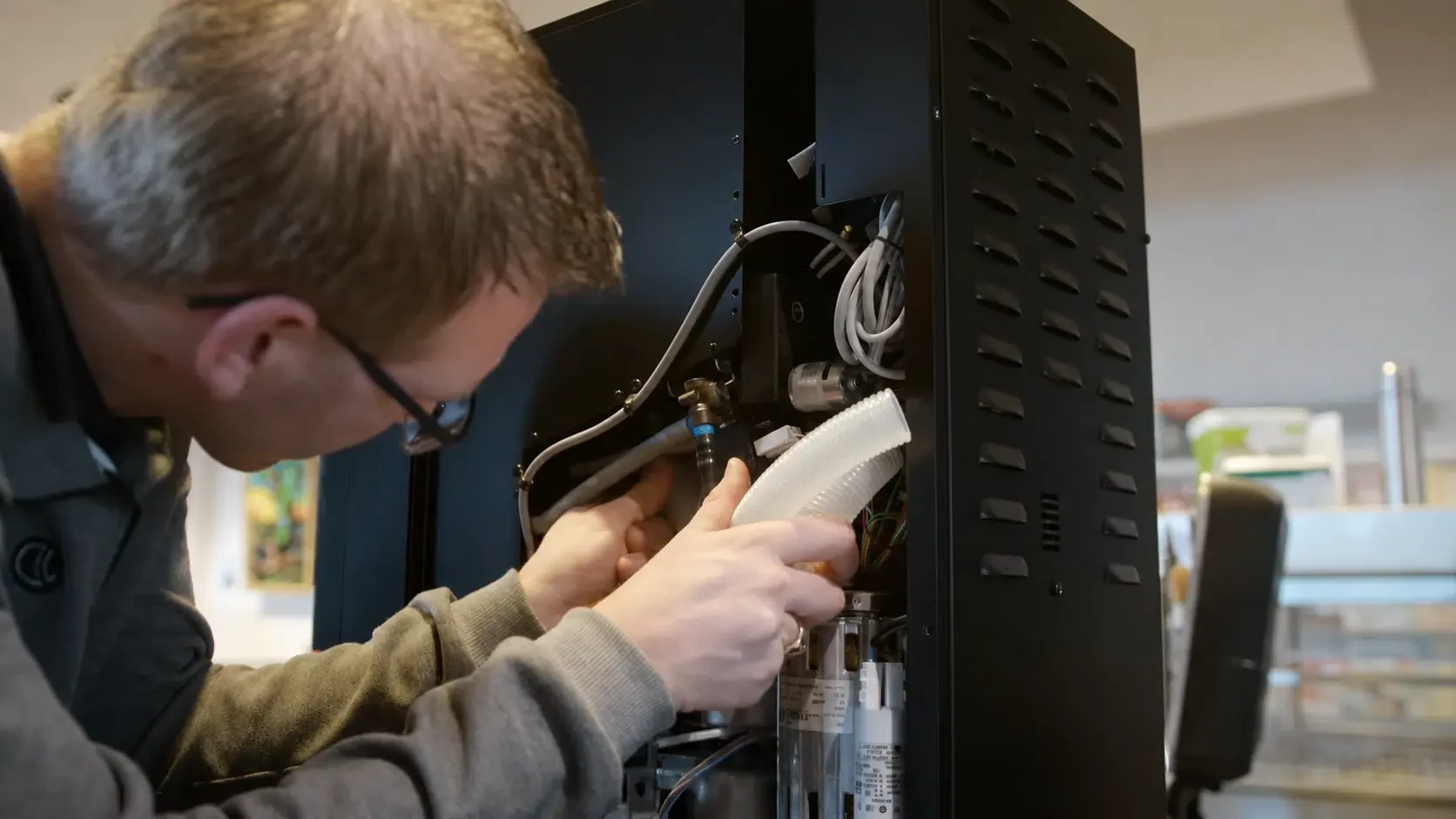 Servicemonteur voert onderhoud uit aan een koffiemachine.