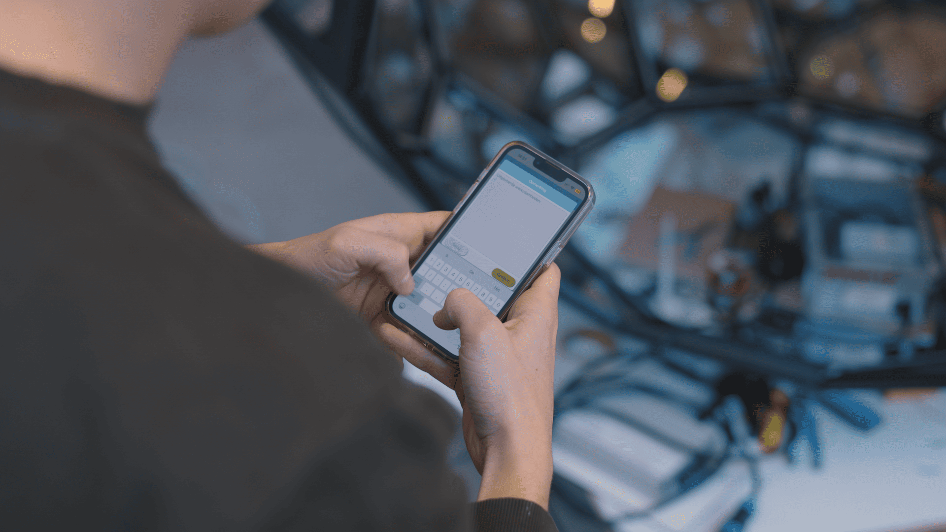 Monteur gebruikt de Simple-Simon werkbon app op een smartphone tijdens het werk.