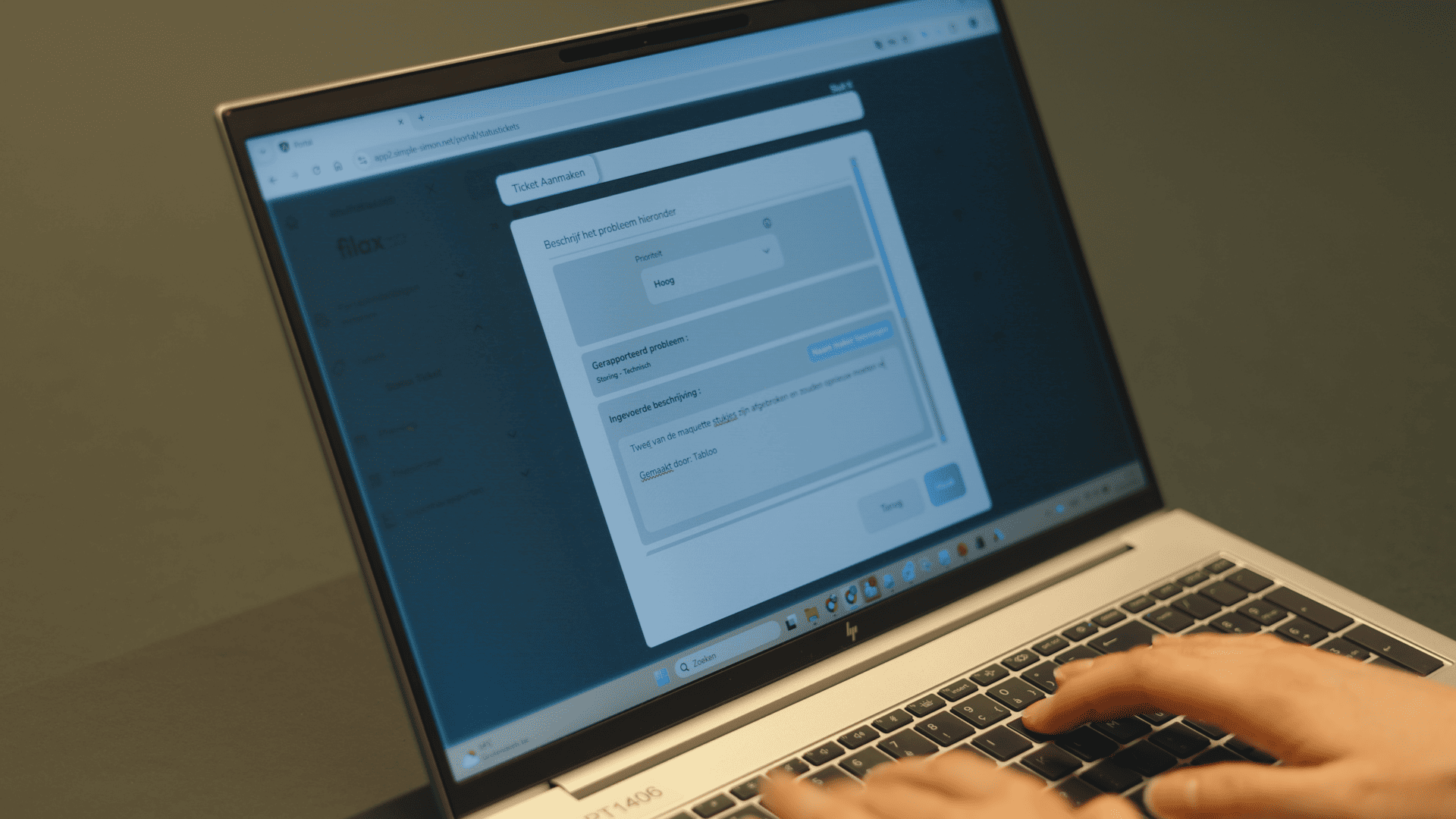 Gebruiker maakt een serviceticket aan in het Simple-Simon klantportaal op een laptop.