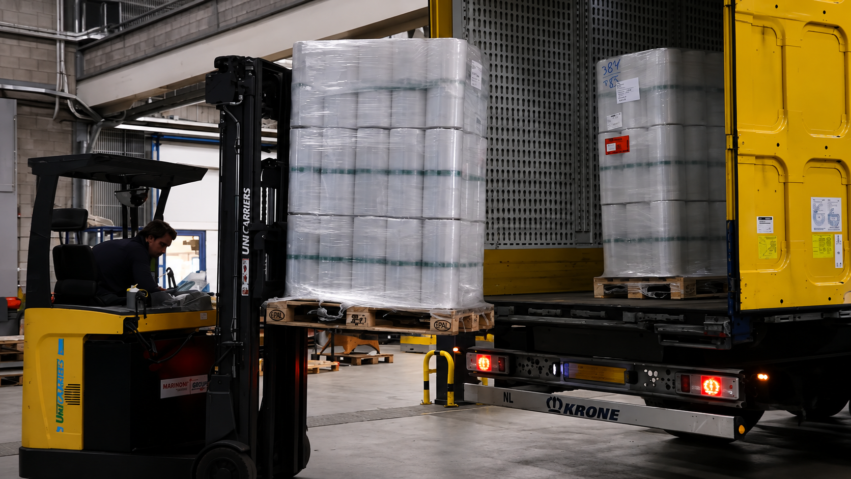 Heftruckchauffeur laadt pallets met goederen in een vrachtwagen.