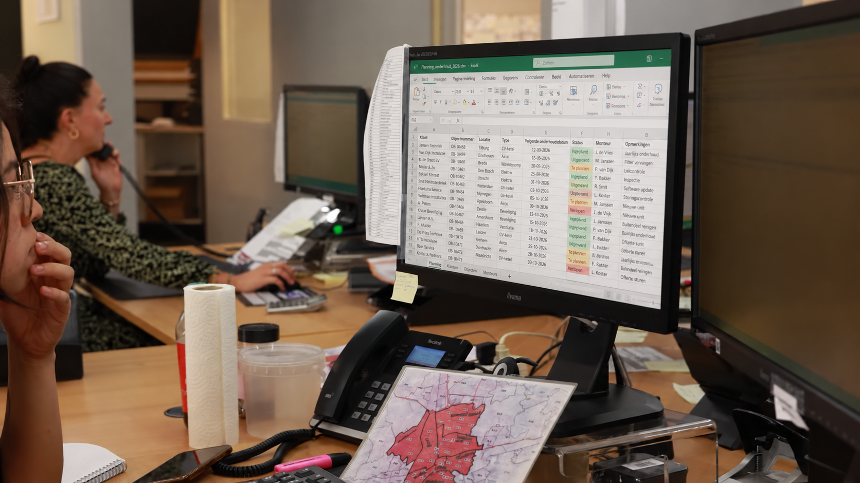 Medewerkers plannen onderhoudswerkzaamheden in Excel op kantoor.