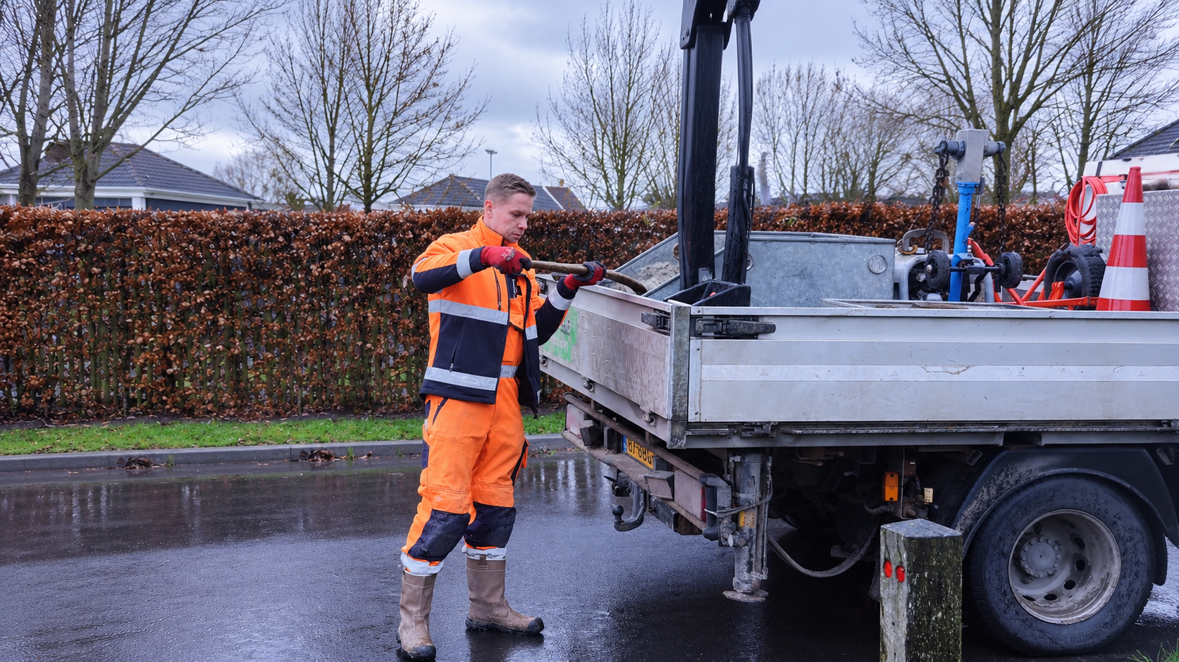 Monteur in werkkleding voert werkzaamheden uit bij een servicewagen.